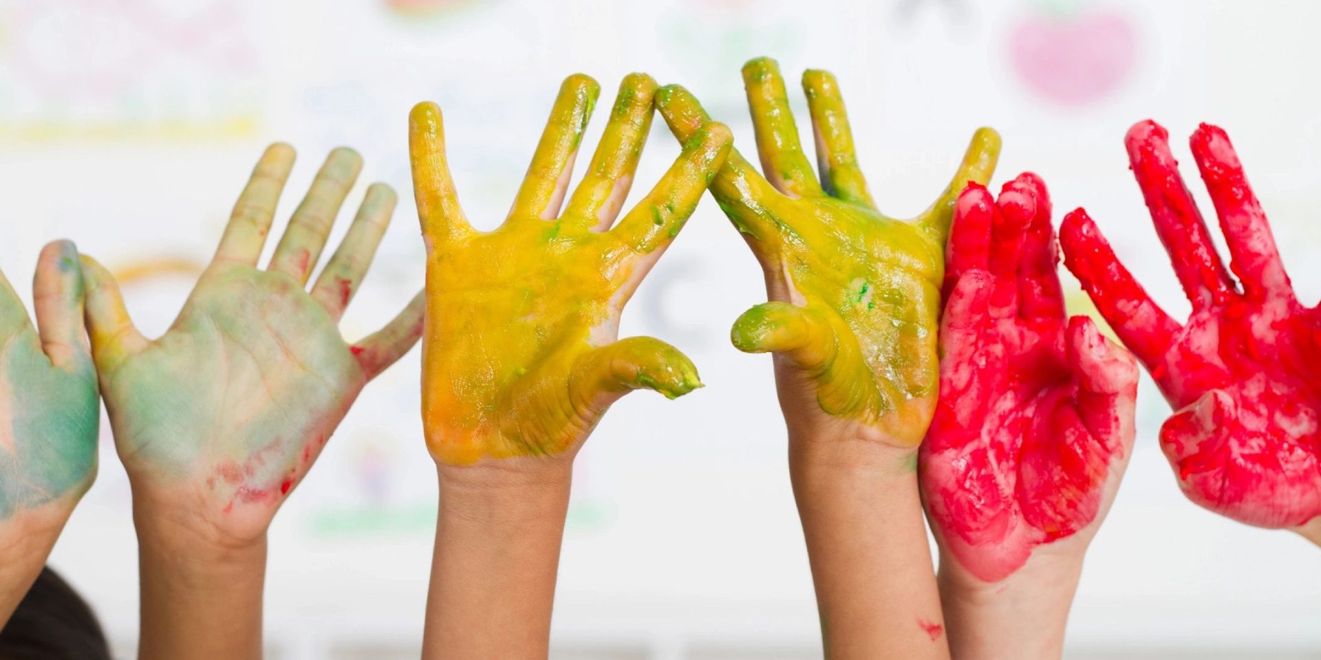 A group of children 's hands covered in paint.