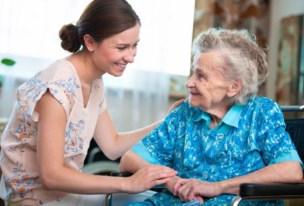 A woman and an old lady smiling for the camera.